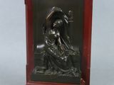 statue représentant une femme assise sur un banc, tenant un oiseau dans la main