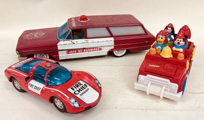 trois voitures jouets assises l'une à côté de l'autre sur une table
