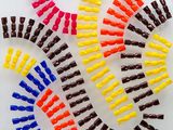 many different colored clips of plastic on a white surface