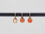 une paire de boucles d'oreilles en or ornées de pierres orange, montées sur un fil métallique