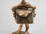 bronze statue of a man with a bag on his back