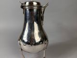 an antique silverplated coffee pot on stand on a white background