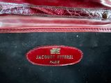 an image of a close up of a red purse with a name tag