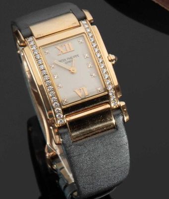 une montre en or sertie de diamants, posée sur un fond noir
