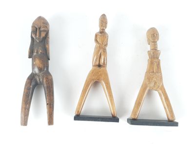 three wooden figurines of a man and a woman on a white background