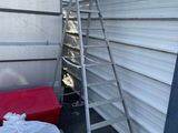 une échelle appuyée contre un mur, à côté d'un lit