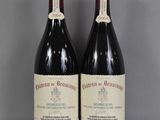 deux bouteilles de vin rouge posées sur une table en verre