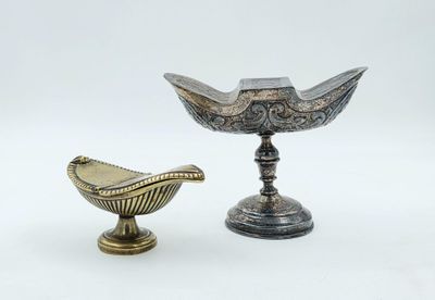 une paire de bougeoirs en métal argenté et un bol en métal argenté
