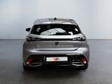 the rear end of a silver car in a room with a white wall