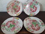 three plates with floral designs on them sitting on a table