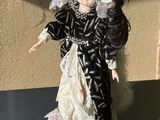 a black and white doll with a white hat and a black and white dress