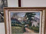 a picture of a painting on a table next to a picture of a house