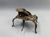 a small metal insect that is sitting on a table