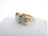 a close up of a gold and diamond ring on a white surface