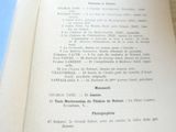 un livre ouvert posé sur une table sur laquelle se trouve une photo