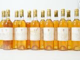 six bouteilles de vin sont alignées sur une surface blanche