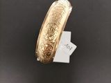 a close up of a gold bracelet on a black surface