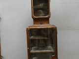 a tall wooden cabinet with a glass door on top of it