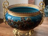 un bol bleu orné de motifs dorés, posé sur une table