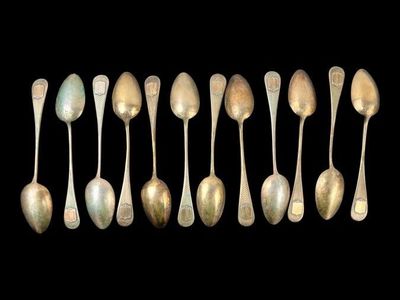 six silver spoons are arranged in a row on a black background