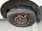 a dirty tire on the side of a white truck