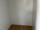a empty room with a wooden floor and a white wall