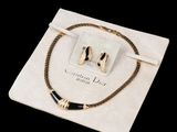 un gros plan sur un collier et un bracelet posés sur un sac blanc