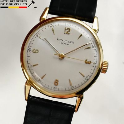 un gros plan d'une montre-bracelet en or avec un cadran blanc