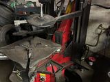 a fork lift in a garage with a tire in the background