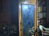 dimly lit living room with bookshelf, chair, table, and television