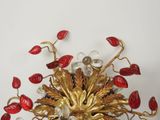 a gold and red flower brooch with leaves on it