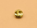 un diamant jaune sur une surface beige clair