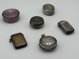 un petit assortiment d'objets en argent posés sur une surface blanche