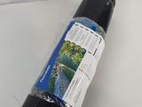 un gros plan sur un rouleau de tissu noir posé sur une surface blanche
