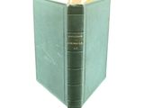 a green book that is open on a white surface