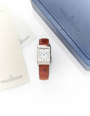 a watch sitting on a table next to a blue box
