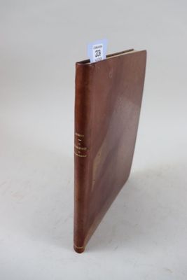 un livre en cuir marron, orné d'une étiquette blanche, posé sur une surface blanche