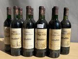 six bottles of wine sitting on top of a wooden table