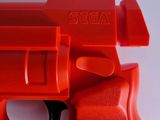 a close up of a red plastic toy gun on a white surface