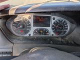 dashboard of a car with a hand on the steering wheel