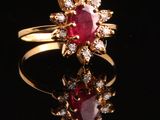 gros plan d'une bague en or avec un rubis et des diamants