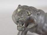 a silver statue of a tiger with its mouth open