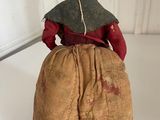 an old doll sitting on top of a white table next to a white wall