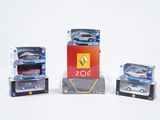 trois petites voitures sont posées sur des boîtes sur une surface blanche