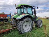 un tracteur vert garé dans l'herbe