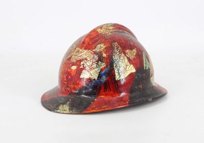 a red hard hat with a gold leaf design on it