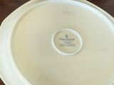 a white plate on a table with a brown table cloth