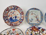 several plates with different designs are sitting on a white surface