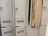 deux casiers dans le couloir d'un immeuble, avec un manteau accroché à la porte