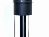 a black toilet with a metal tank on top of it
